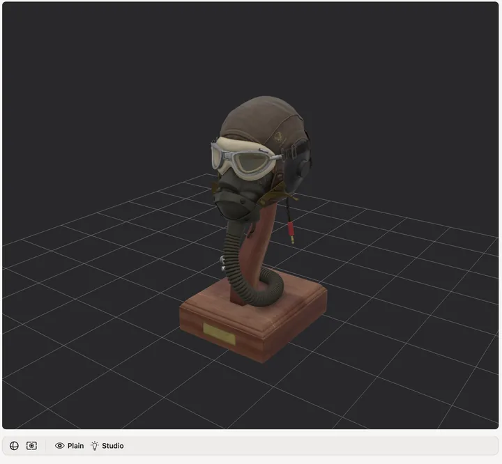 The 3D bench: a detailed flight helmet with leather cap, goggles and oxygen mask on a wooden stand, lit in the studio room.